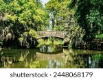Stone bridge over pond with green foliage in City Park, New Orleans