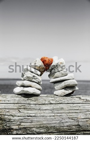Stone bridge with red keystone built from pebbles against blue sky