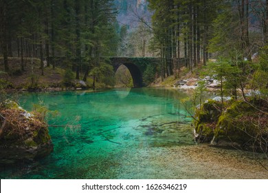 Stone bridge at the river spring of Kamniska Bistrica in Slovenia in dry winter time. Cold enchanted bridge with flowing water underneath in the middle of the forest. - Powered by Shutterstock - Get 15% off with code: PIKWIZARD15