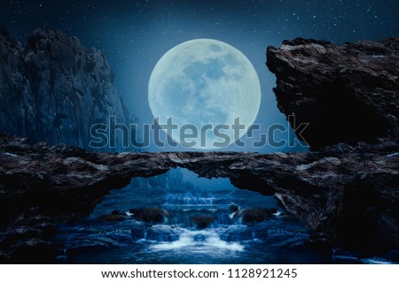 A stone bridge with a waterfall on the beautiful full moon night.