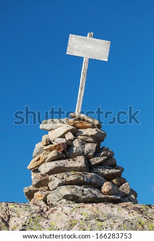 Stone cairn with empty white wooden label