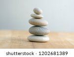 Stone cairn on striped grey white background, five stones tower, simple poise stones, simplicity harmony and balance, rock zen sculptures