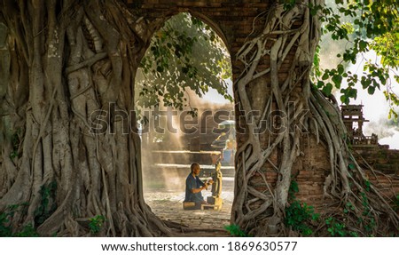 Stone carver working with hammer and chisel at marble column. Yellow marble angel carving. In the archaeological site