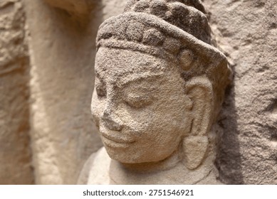 Stone carving of apsara or devata decorating an ancient khmer temple in cambodia