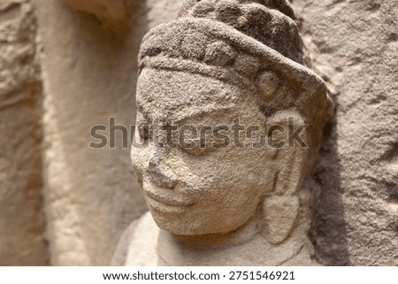 Stone carving of apsara or devata decorating an ancient khmer temple in cambodia