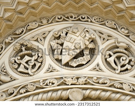 Stone carving on a 19th century university building at the University of Toronto, with coat of arms and educational heraldry and symbols