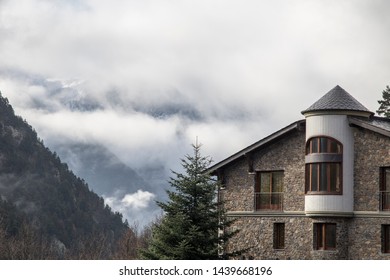 Stone Chalet And Snow Capped Mountains In Pyrenees. Andorra