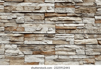 Stone cladding wall made of  striped stacked slabs of  gray and brown rocks. Panels for exterior. Background and texture.