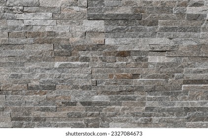 Stone cladding wall made of striped stacked bricks of gray 
 and brown rocks. Panels for exterior, background and texture.