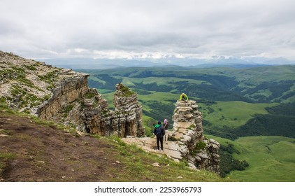 Stone cliffs and cliffs on the green Bermamyt plateau in Karachay-Cherkessia on a cloudy summer day with a hazy haze on the horizon and a space for copy - Shutterstock ID 2253965793