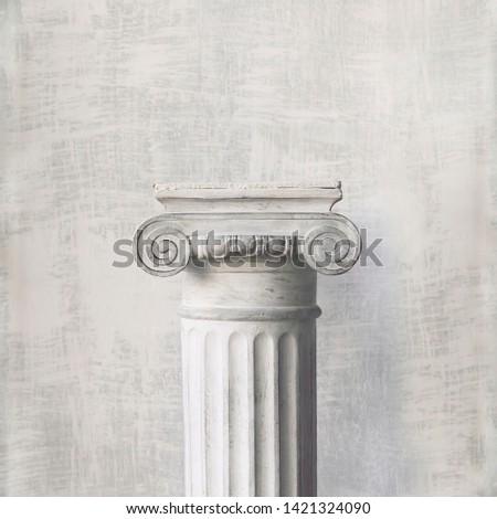 Stone column on light gray background. Close-up, copy space, front view, toned, square format