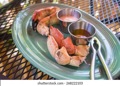 Stone Crab Legs Served With Dipping Sauce In A Restaurant