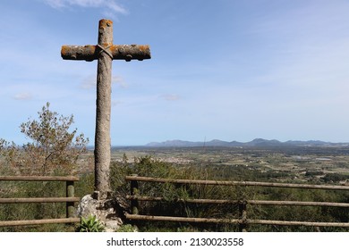 Stone Cross In Homage To Fray Junípero Serra. In The Background, Landscape Of 