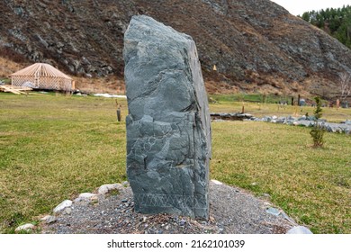 A stone with a deer pattern on the background of nature. Prehistoric attraction Altai.