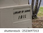 A stone engraving on a wall “Library of Hawaii 1911” at the Hawaii State Library in downtown Honolulu Hawaii USA