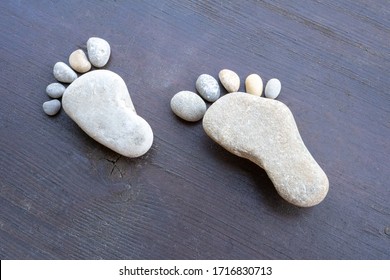 Stone feet on wooden background.