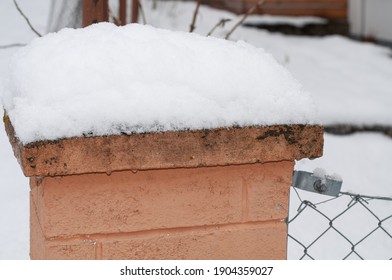 A Stone Fence Post At A Metal Fence In Winter Covered With Snow