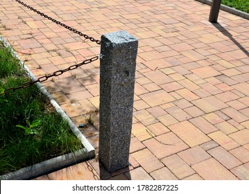 Stone Fence Post At The Monument To The Fallen In The War. Linked To Other Metal Chain.