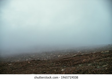 Stone field in dense fog in highlands. Empty stone desert in thick fog. Zero visibility in mountains. Minimalist nature background. Dark atmospheric foggy mountain landscape. Lichens on sharp stones. - Powered by Shutterstock