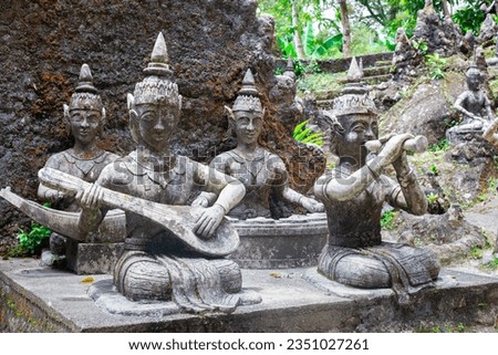 Stone figurines of ancient mythical musicians in traditional Thai culture. Magical Buddha Garden on Koh Samui.