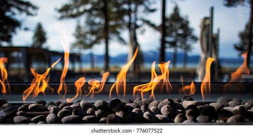 Steinfeuerlöschgrube mit Flammen und Bäumen auf dem Hintergrund Im Freien