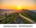 Stone footpath and wooden fence leading a long The Great Ridge in the English Peak District