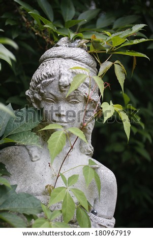 A stone garden statue of a female elf.