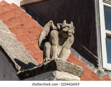 Stone Gargoyle On The Roof Of A House.