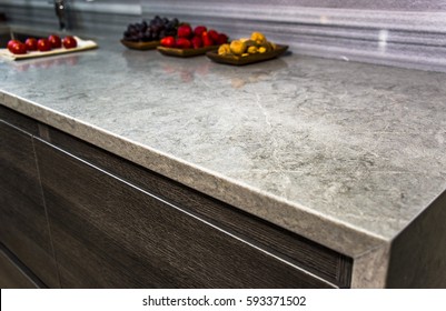 stone gray worktop with dark kitchen cabinets, granite countertop over modern kitchen cabinets with blue motion without handles - Shutterstock ID 593371502