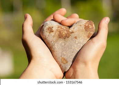 Stone Heart in female hands - Powered by Shutterstock