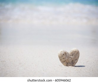 Stone heart shape standing on summer beach sand, love concept. - Powered by Shutterstock