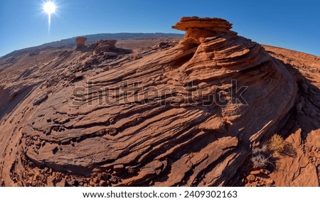 A stone hoodoo and wavy sandstone at Ferry Swale in the Glen Canyon Recreation Area near Page Arizona.