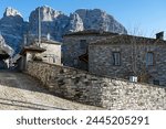 Stone houses of traditional architecture and cobble-stone narrow street at the village of Papigo in Epirus, Greece in winter