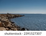A stone jetty at sherwood island state park in westport connecticut on a sunny  day.