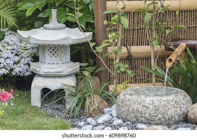 Stone Lantern And Bamboo Fountain In Japanese Garden