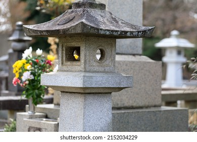 Stone Lanterns And Offering Flowers In The Grave Yard