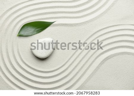 Stone and leaf on sand with lines. Zen concept