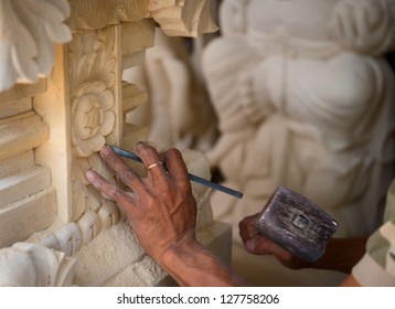 Stone Mason At Work Carving An Ornamental Relief