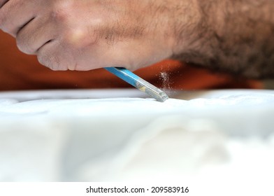 Stone Mason At Work Carving An Ornamental Relief