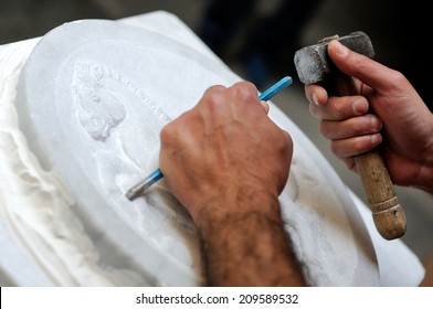 Stone mason at work carving an ornamental relief