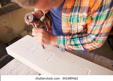 Stone Mason At Work On Carving In Studio