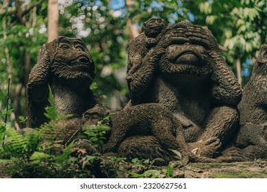 Stone monkeys statues in sacred monkey forest. Old decorative monkey sculptures in ubud sacred forest
