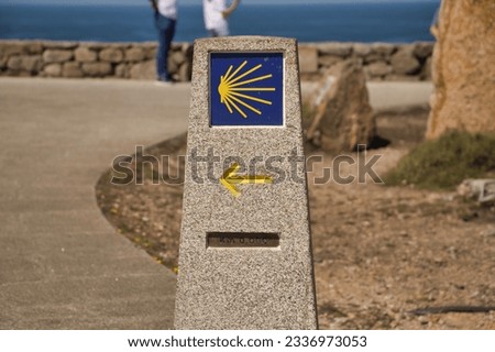 Stone monolith marking the zero kilometer of the road to Santiago, with arrow and shell. Concept pilgrim, road, religion, journey.