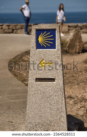 Stone monolith marking the zero kilometer of the road to Santiago, with arrow and shell. Concept pilgrim, road, religion, journey.