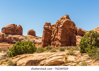 Stone monoliths of unusual shape in the middle of a shrub desert in the Arches National Park, Utah, USA - Shutterstock ID 742349329