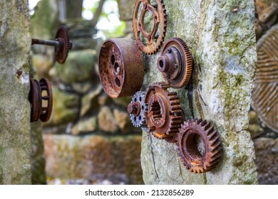 A Stone In The Park Is Inlaid With A Pile Of Rusty Gear Sculptures