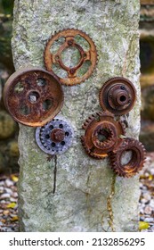 A Stone In The Park Is Inlaid With A Pile Of Rusty Gear Sculptures