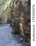 A stone path between large mountains of rocks on the shores of the sea