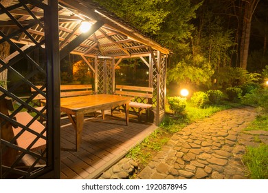 Stone Path To The Lighted Cozy Wooden Patio Gazebo In The Backyard