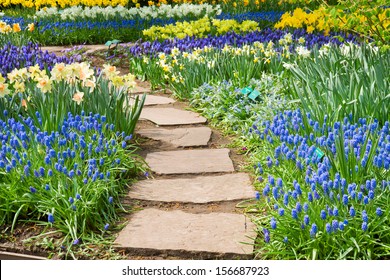 Stone Path Winding In Spring Flower Garden